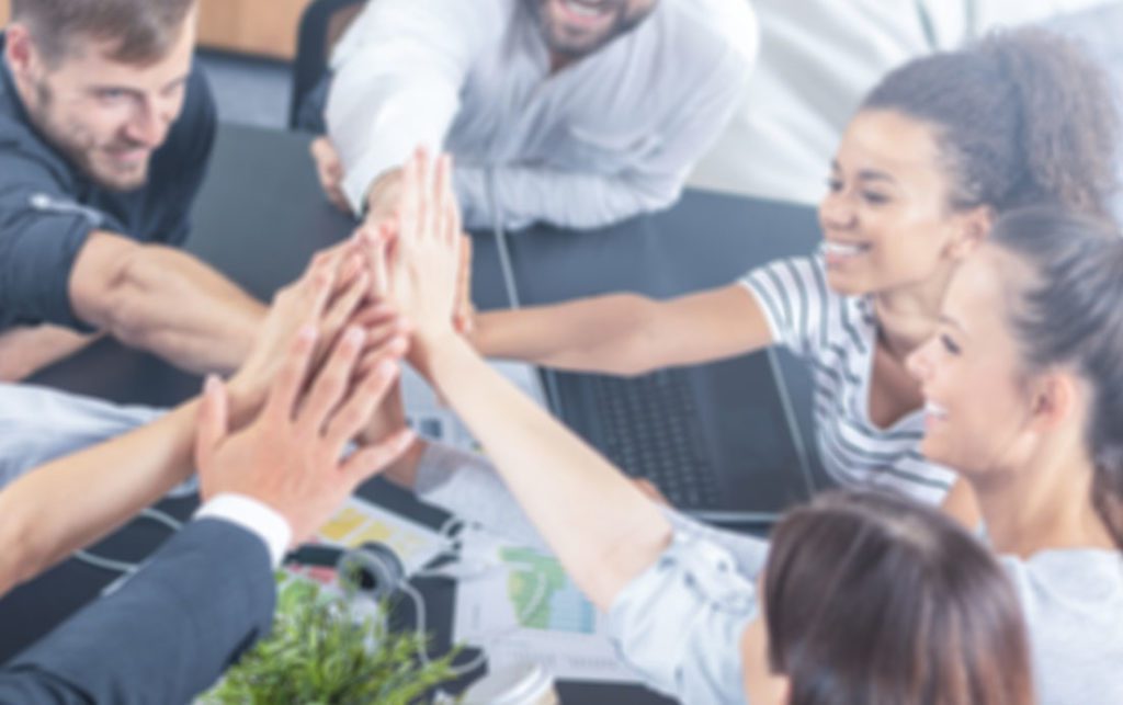 A group of people sat in a circle giving each other a high-five